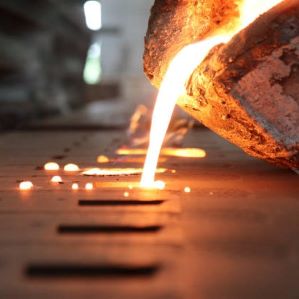 Molten metal being poured into a form at a foundry.