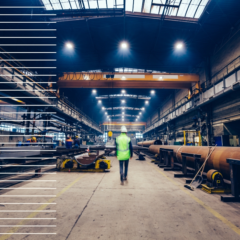 Worker in PPE walking through a steel plant.