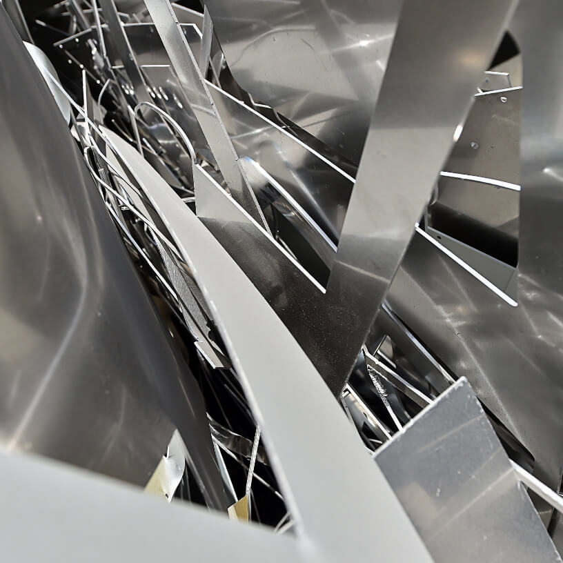 Close-up of aluminum scrap metal in greyscale.